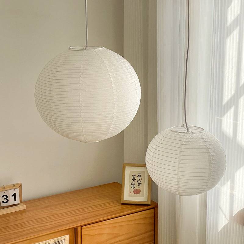 Two Japanese Rice Paper Pendant Lights in different sizes hanging in a serene room, showcasing versatile lighting design options.