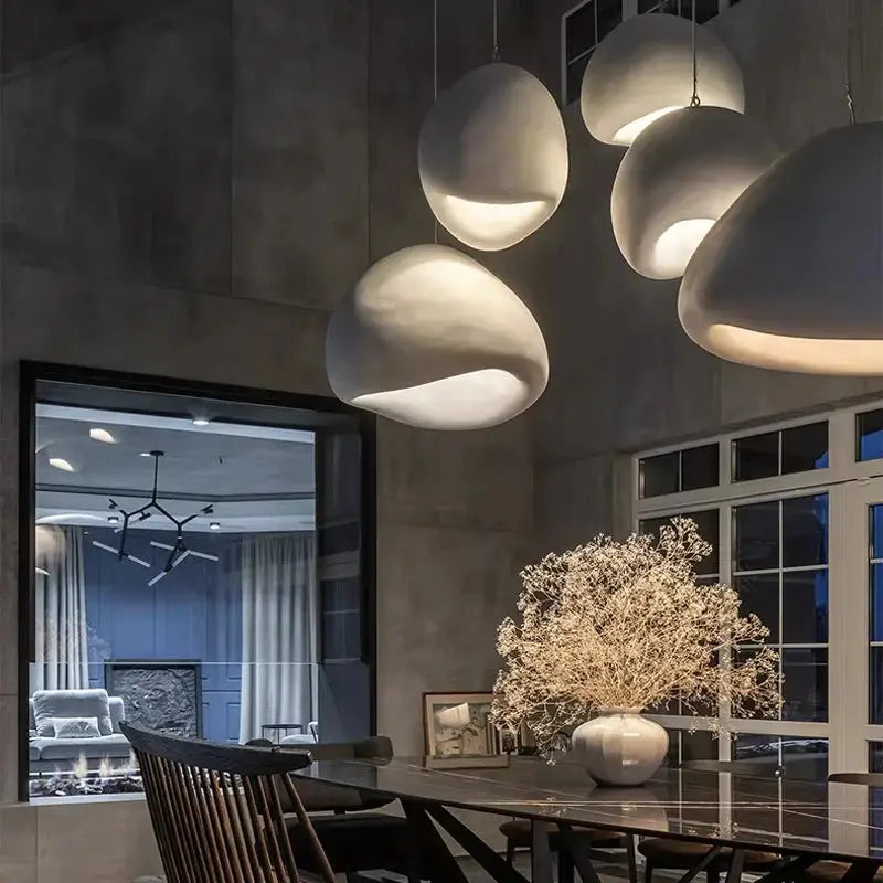 Cluster of Wabi Sabi LED pendant lights in modern dining room. Organic shapes and soft lighting elevate the ambiance and interior design.