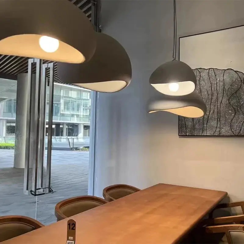 Modern Wabi Sabi LED pendant lights over dining table in contemporary setting. Sculptural design enhances home decor and lighting aesthetics.