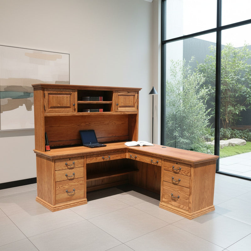 Traditional T641 Office Desk & Return in a modern office with large windows, highlighting its L-shaped design and utility drawers.